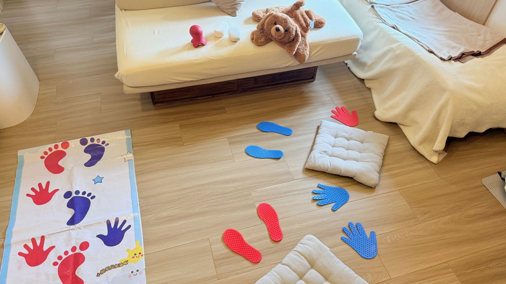 Pivotal Paediatric Development home-visit OT setup in a Hong Kong living room with sensory mats and a teddy bear