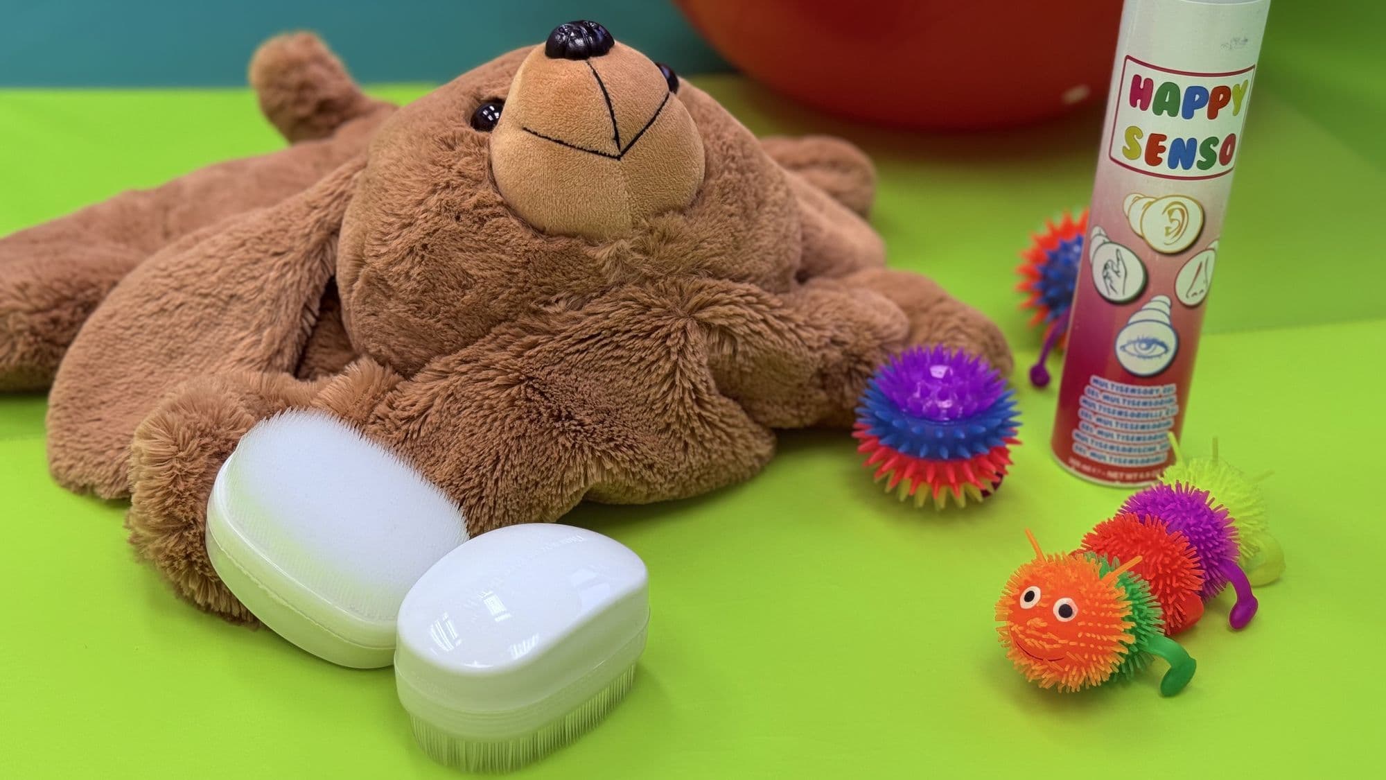 Multisensory stimulation tools — teddy bear, Happy Senso multisensory gel, and tactile spiky balls